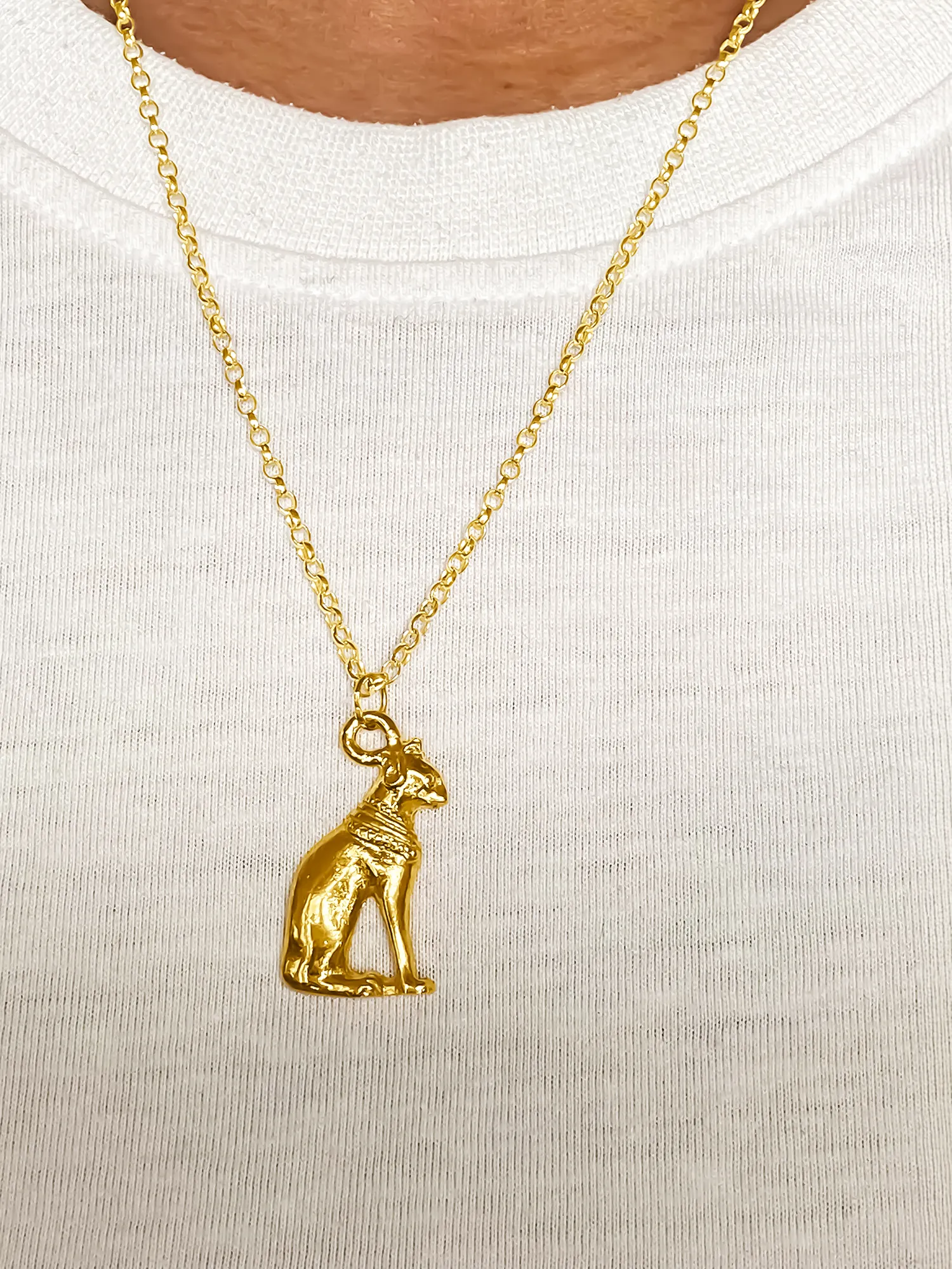 Gold Bast Cat pendant worn on a white T-shirt