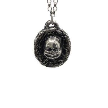 Close-up of Buddha Face Pendant in sterling silver, front view on white background