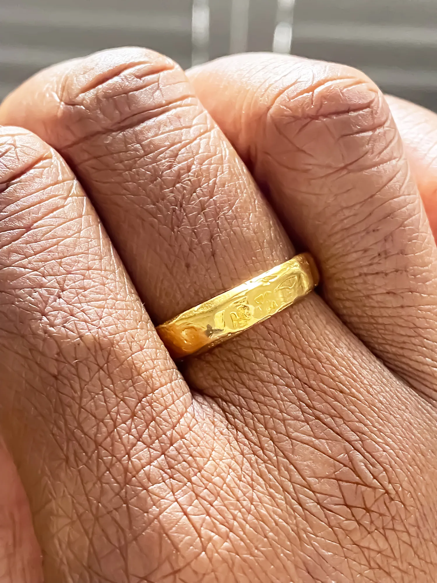 Close-up of gold textured ring on finger