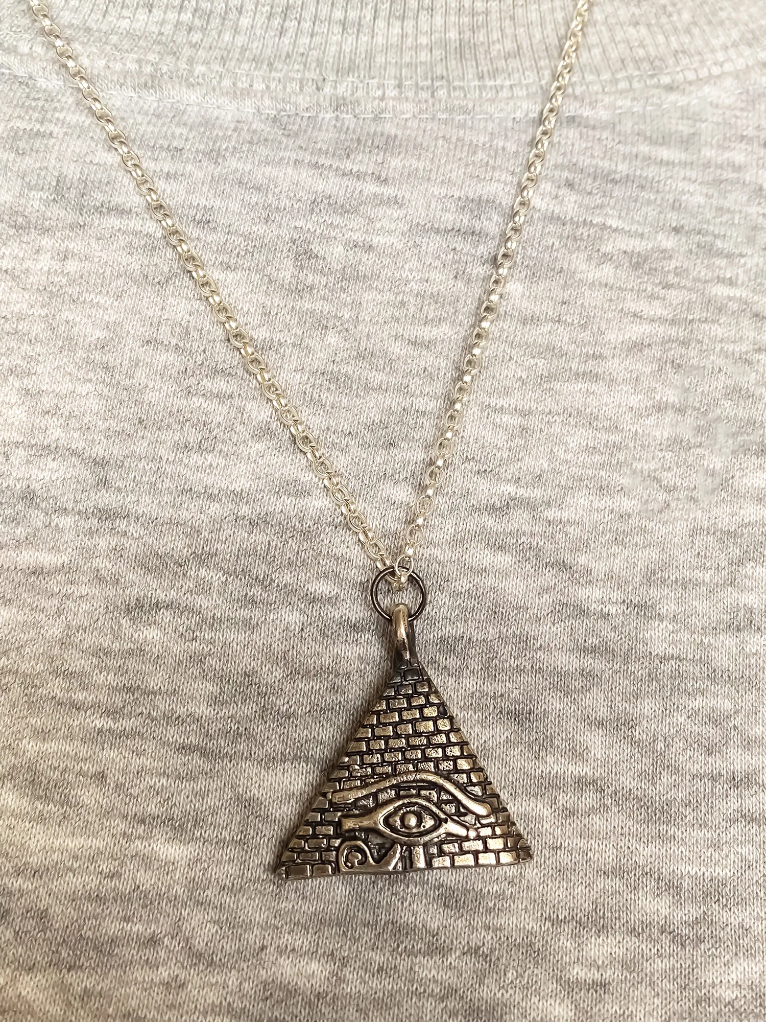 Horus Eye Pyramid Pendant worn with casual grey top
