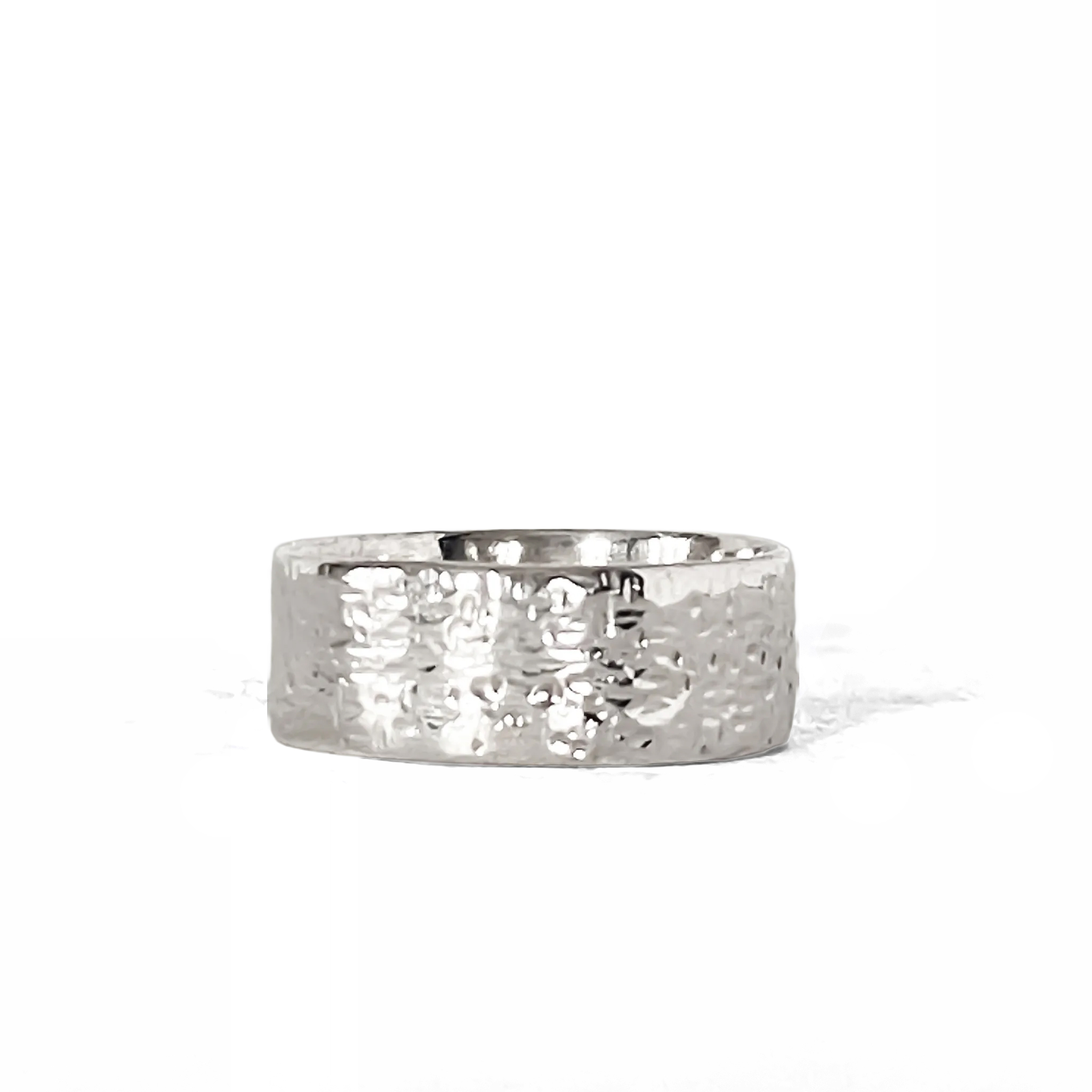 Hammered silver ring photographed on a white background, angled to show texture.