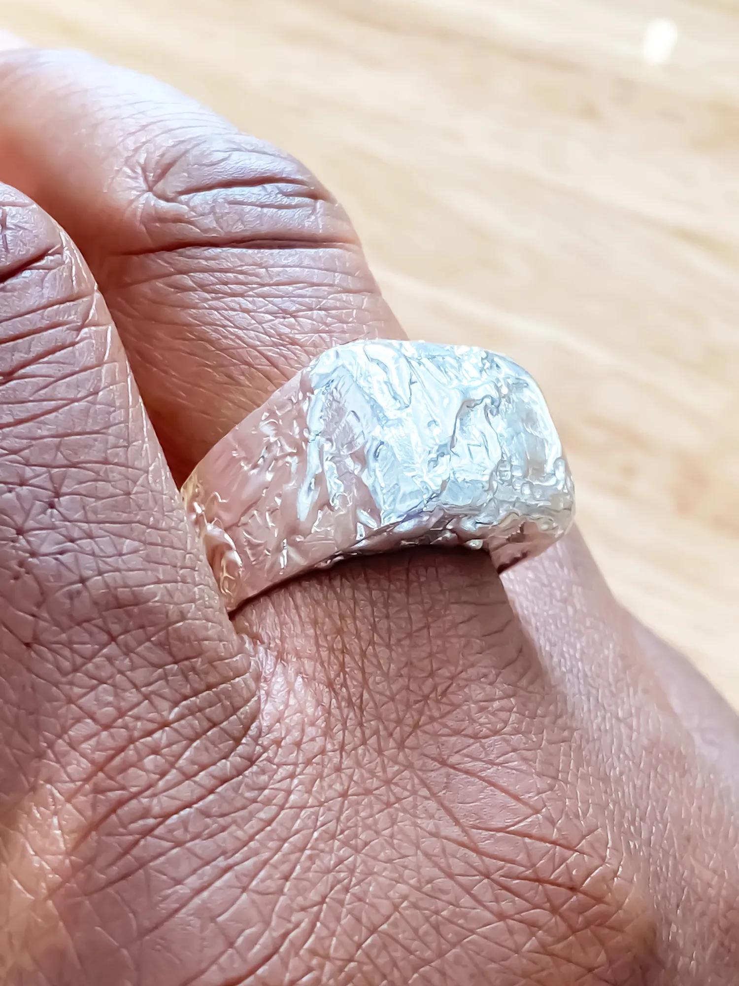 Textured Signet Ring worn on hand, showing curved bevel and texture