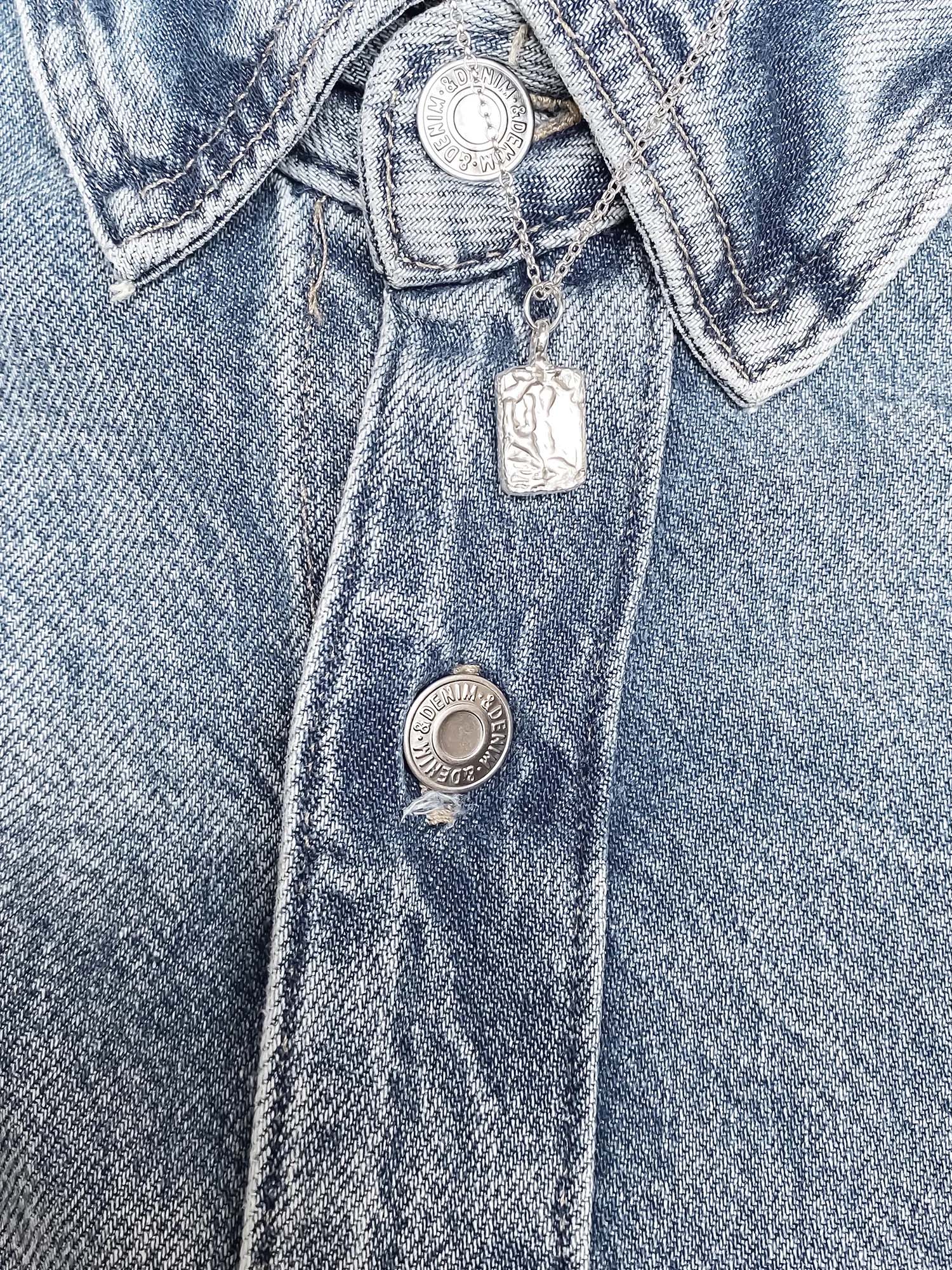 Silver rectangular pendant necklace styled with vintage denim jacket