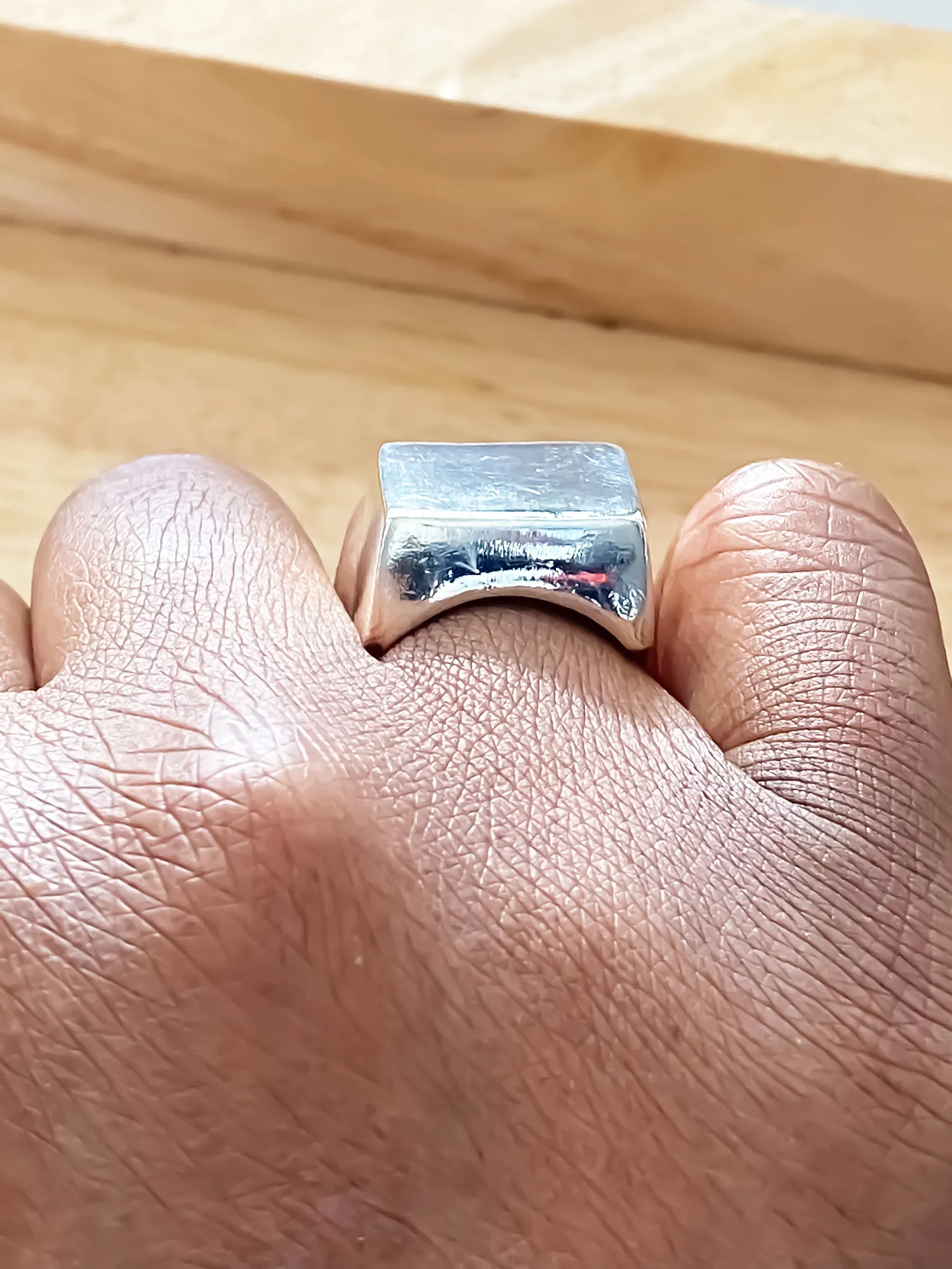 Close-up of silver square signet ring worn on finger from different perspectives