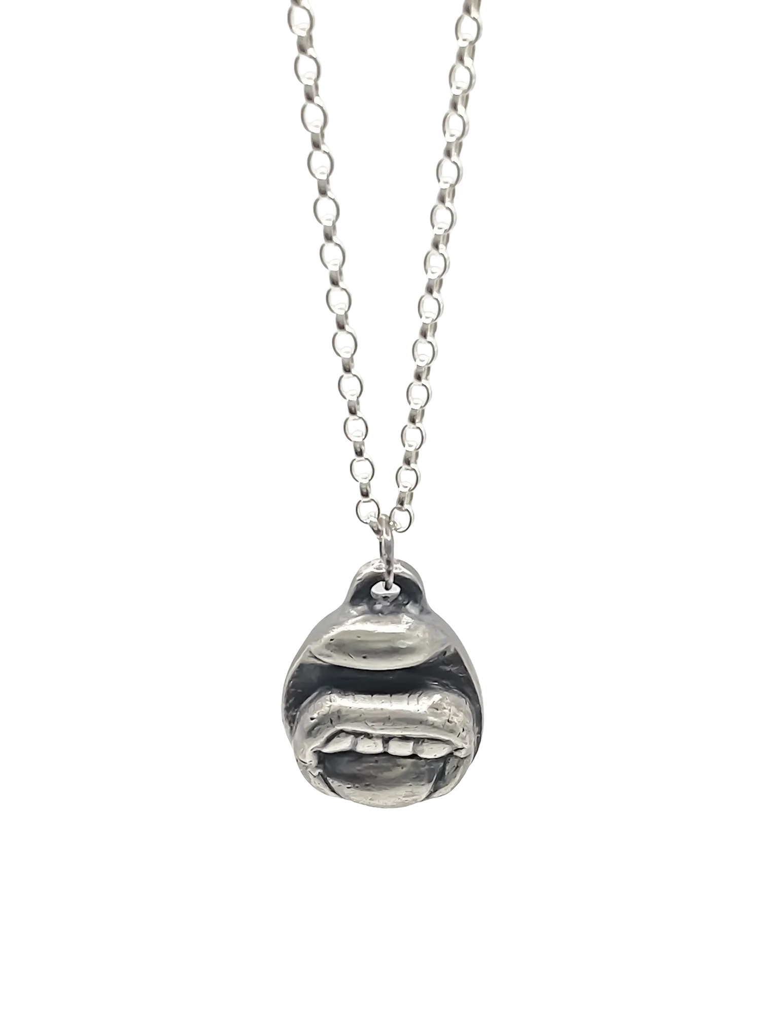 Close-up of the Tongue & Teeth Pendant in sterling silver on a chain, set against a white background