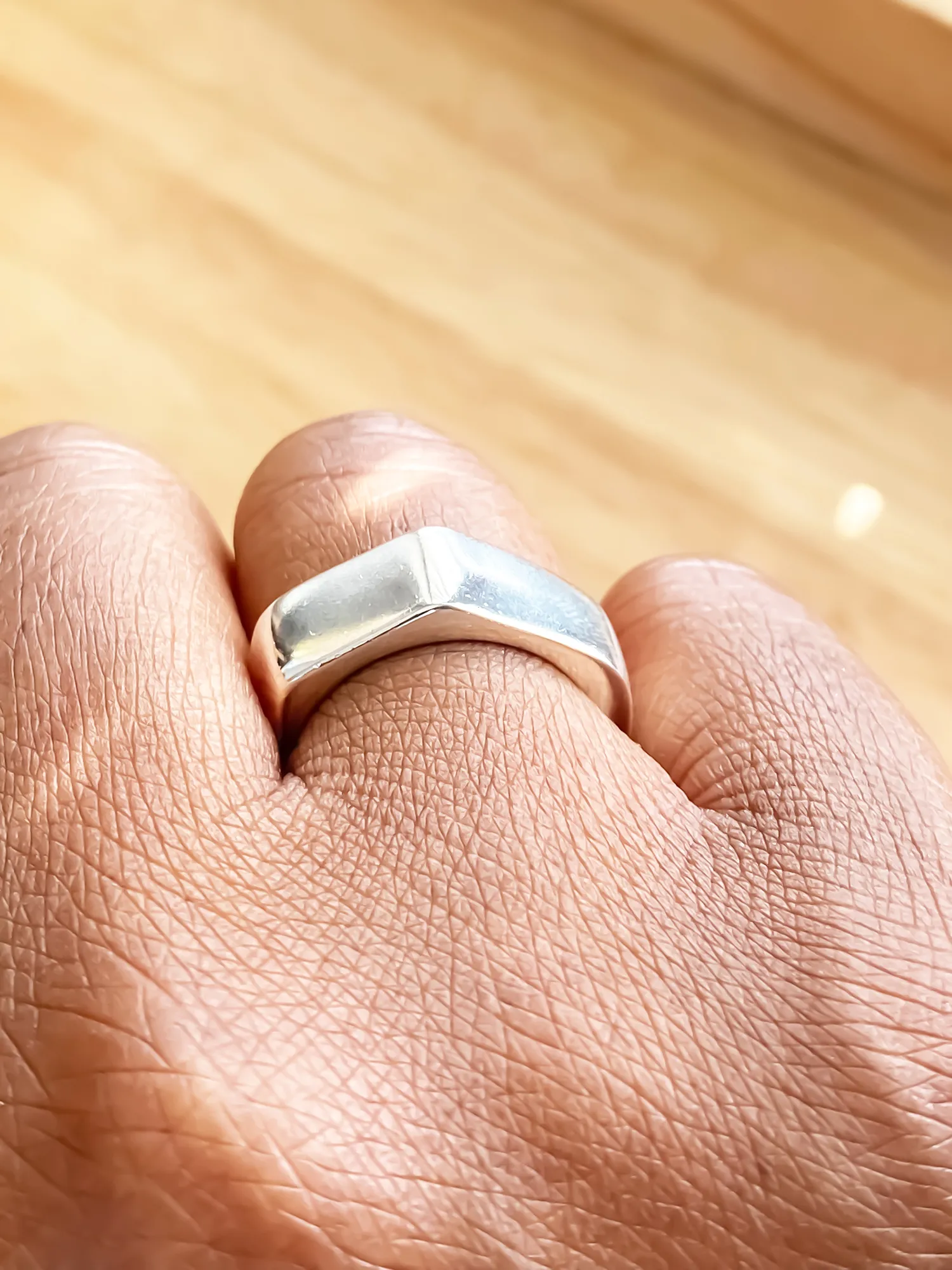 Close-up of the Wonky Nut Ring worn on hand, angled view
