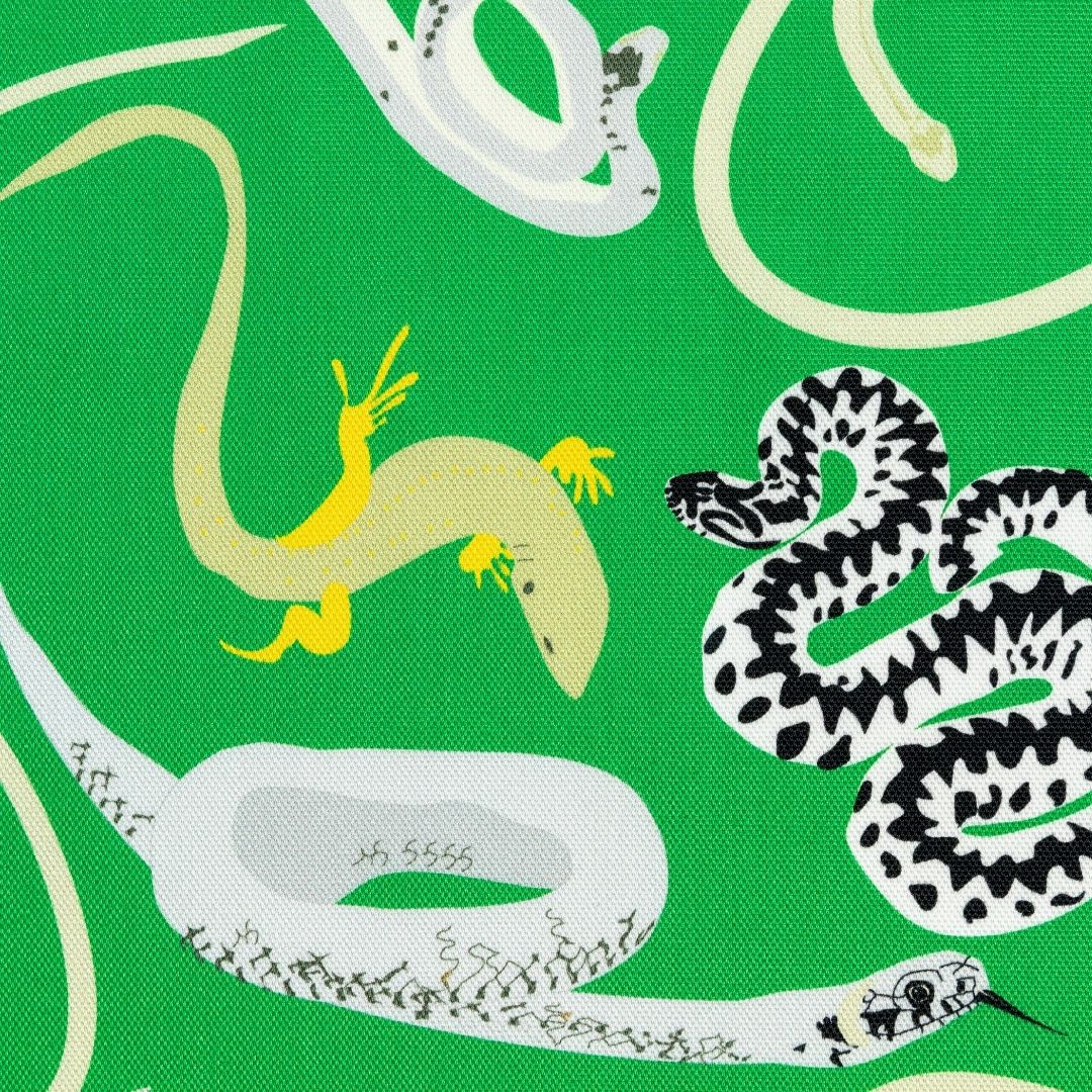 Close up detail of green fabric with pattern of snakes and lizards