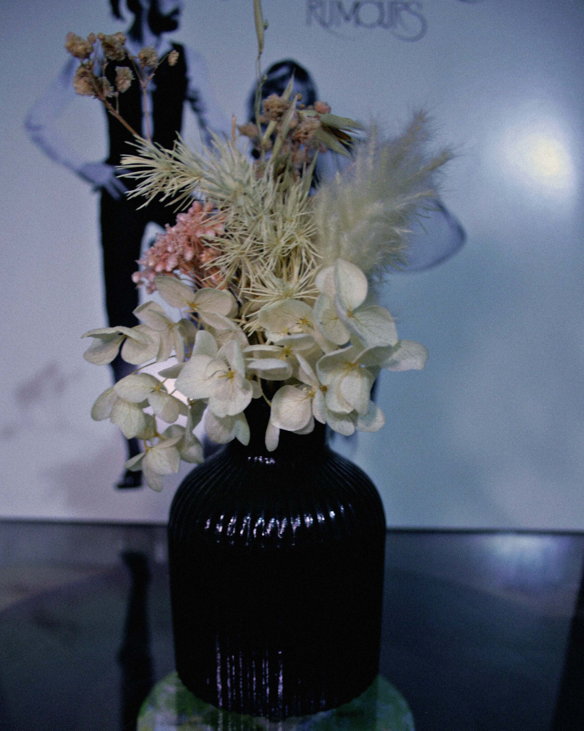 Black handmade organic resincrete vase on a record player with a Fleetwood Mac vinyl in the background
