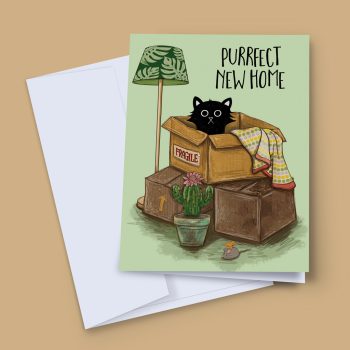 Purrfect New Home greeting card by Baldy and the Fidget, showing a black cat sitting in a fragile-labelled moving box surrounded by packing boxes, a floor lamp, cactus and toy mouse on a sage green background, displayed with a white envelope.